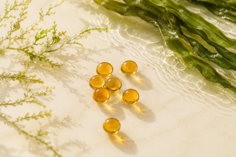 Perlas de omega 3 sobre fondo claro con microalgas verdes